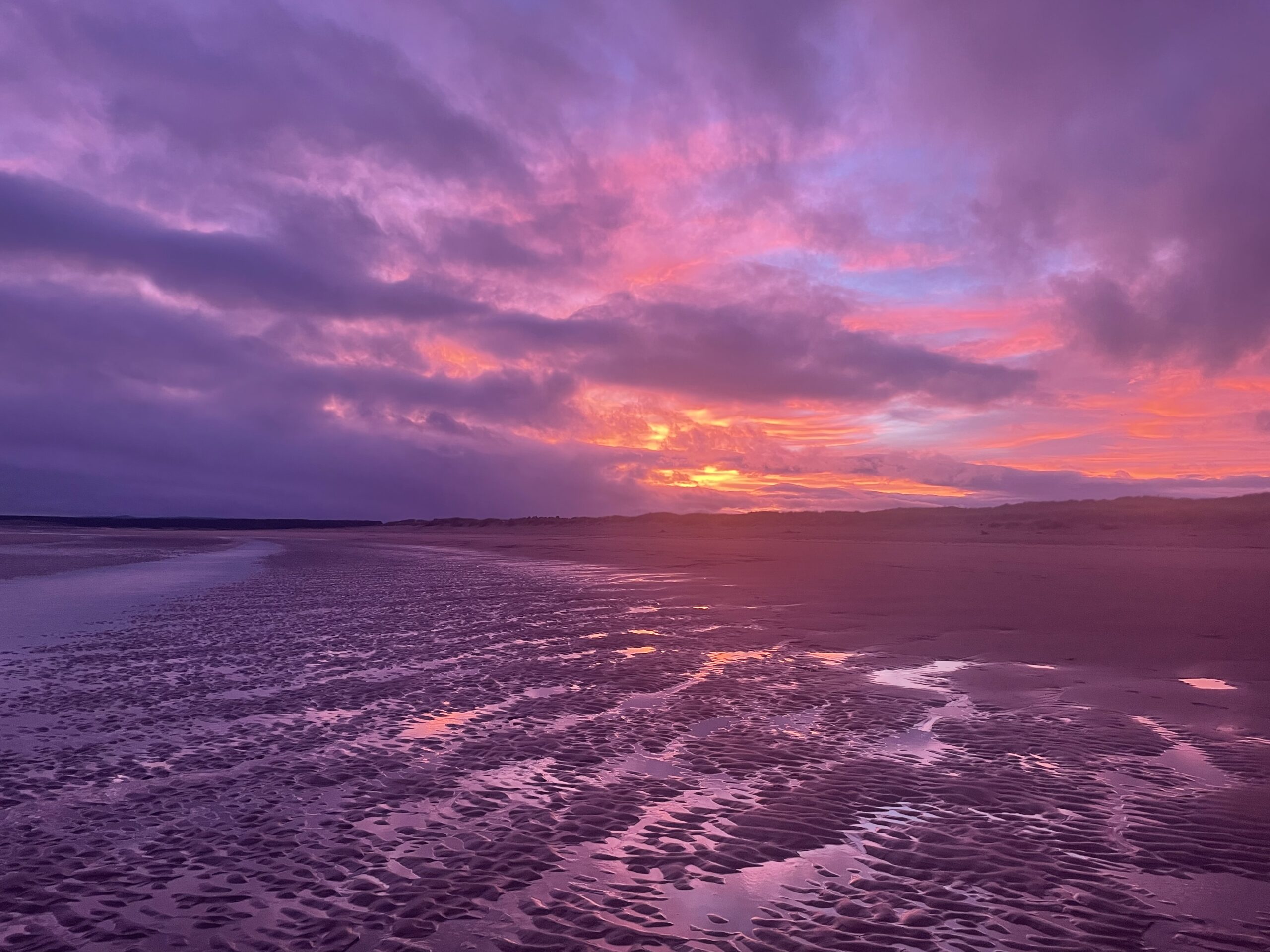 Beach with purple clouds at sunset