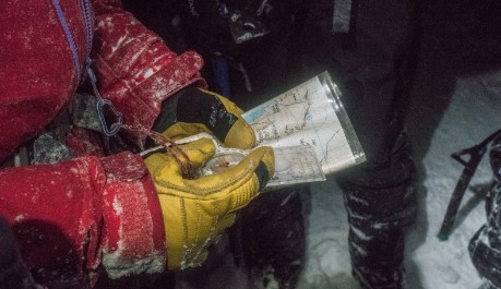 Person navigating in the dark with a compass and map